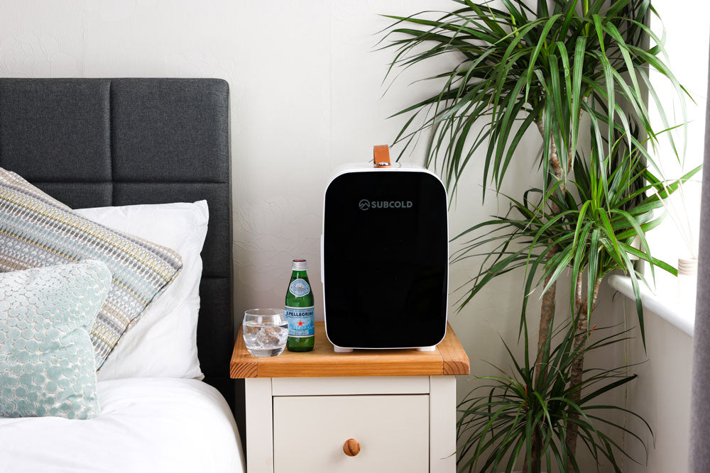 White portable mini fridge with black door and brown carry handle