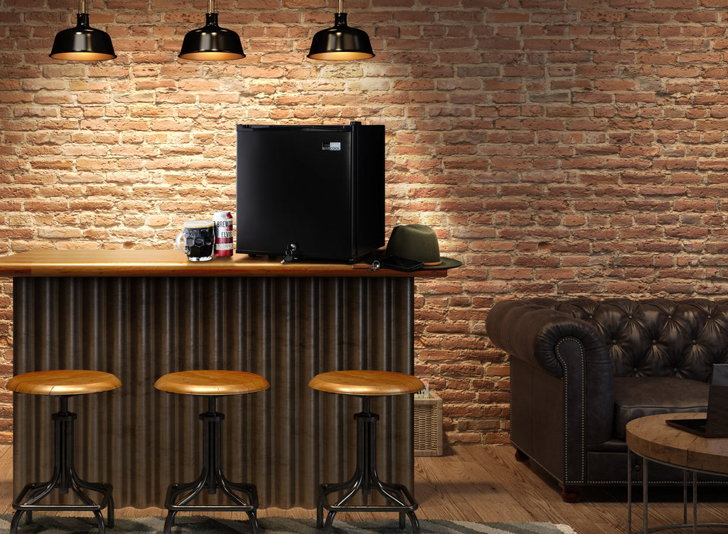 Black mini bar fridge on countertop in a lounge setting, door closed