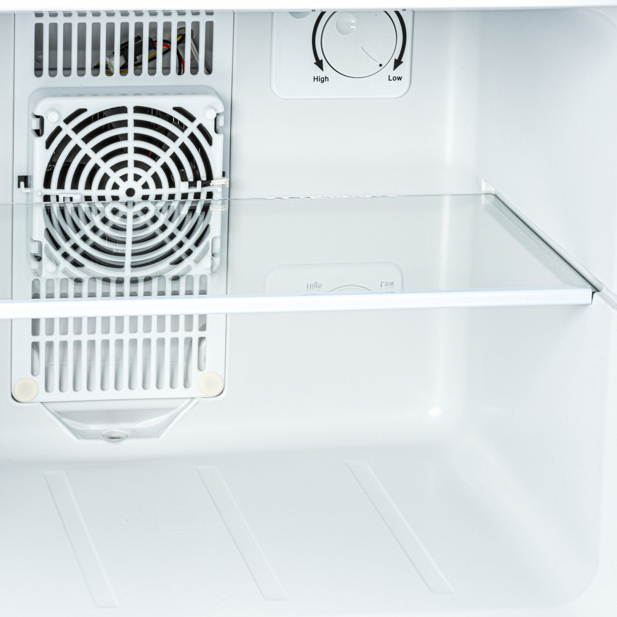 White mini fridge interior close-up with fan grille and temperature control