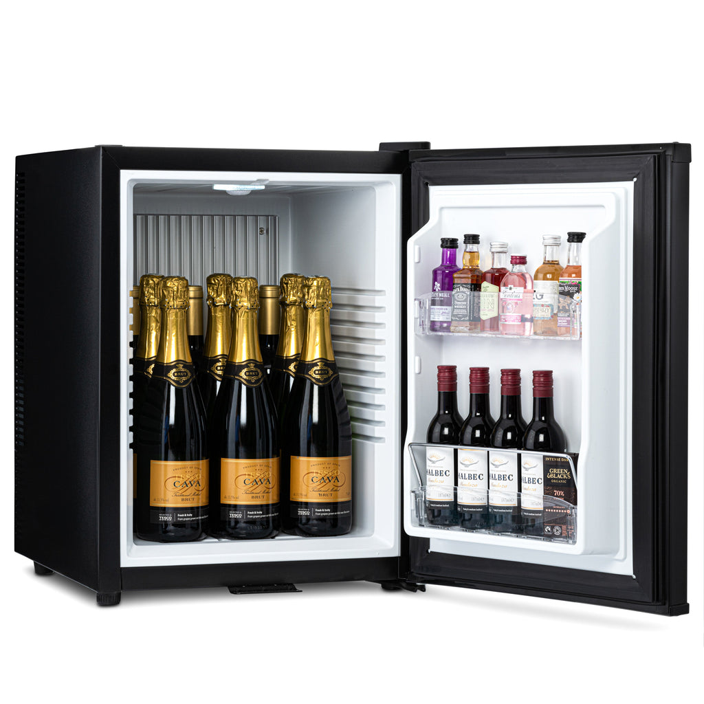 Mini bar fridge open with champagne bottles and drinks on white shelves