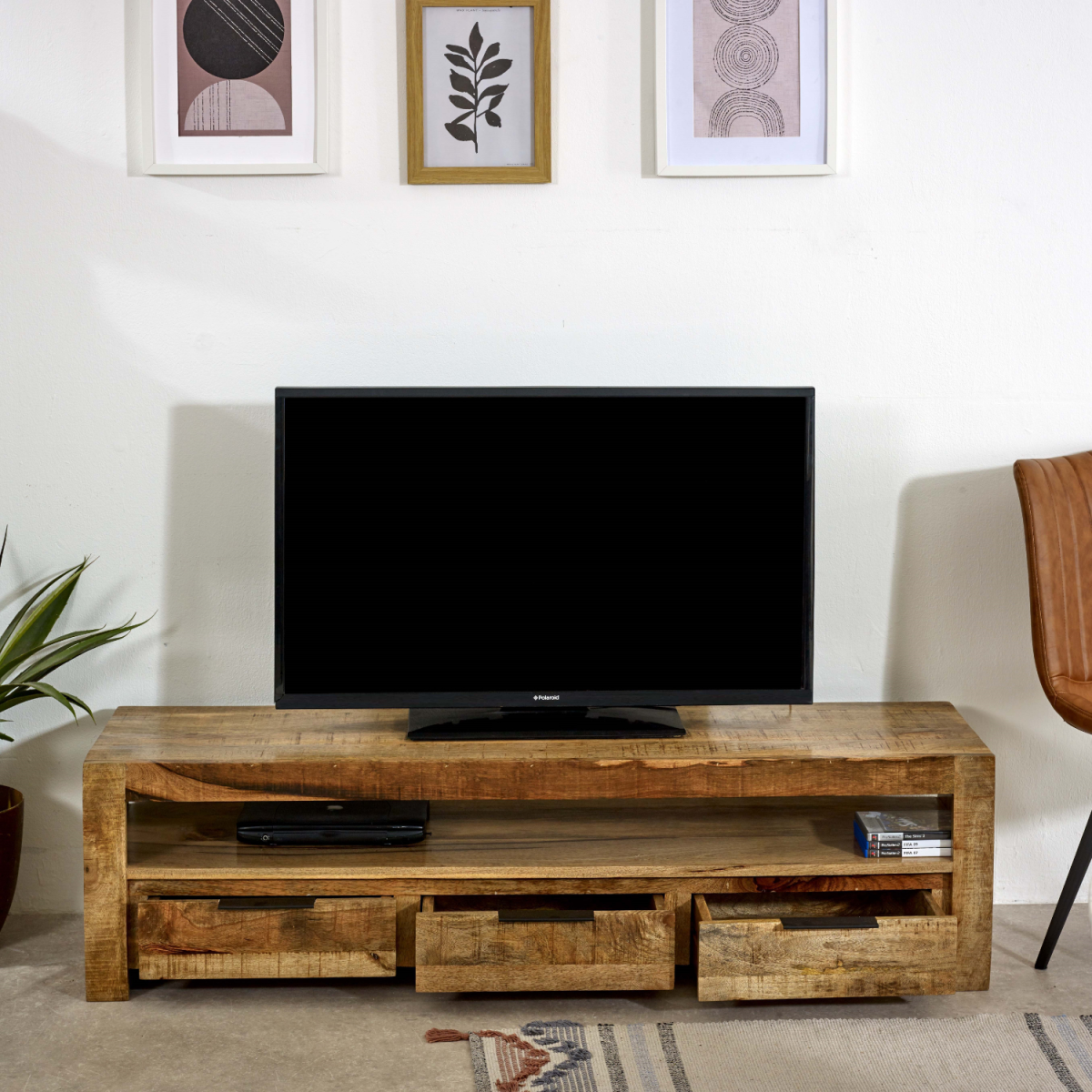Rustic wood TV console with open shelf and three drawers; flat-screen TV centered on top.