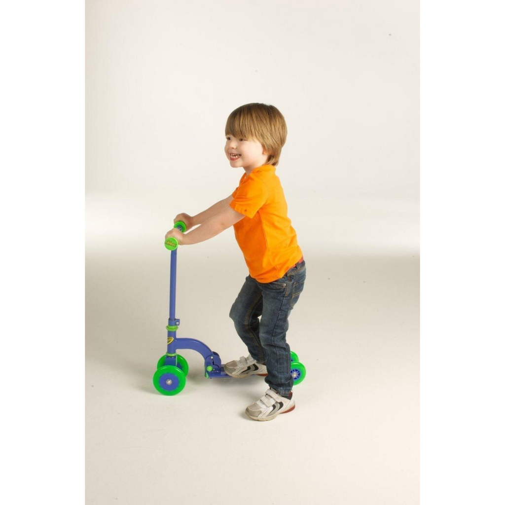 Child standing on blue-and-green three-wheel push scooter with green wheels