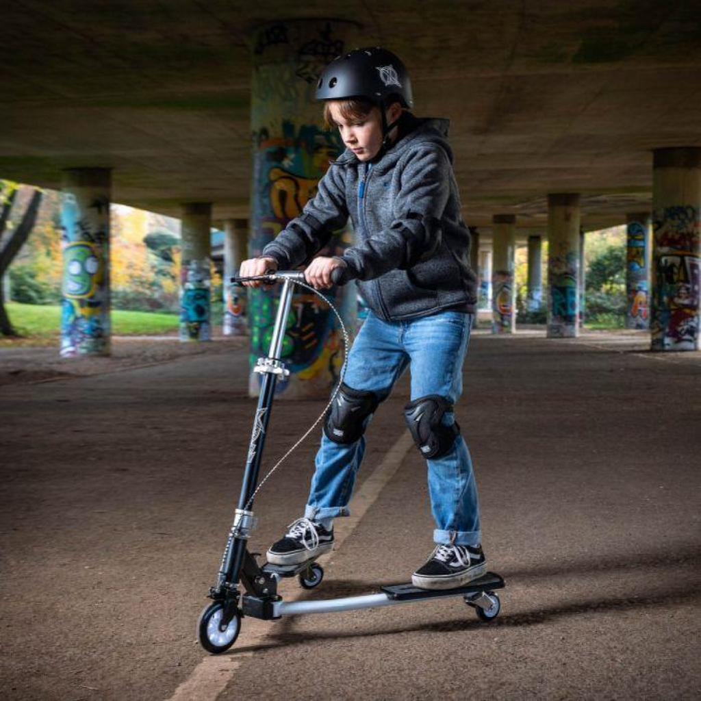 Kid riding white kick scooter with black frame and two foot decks, wearing helmet
