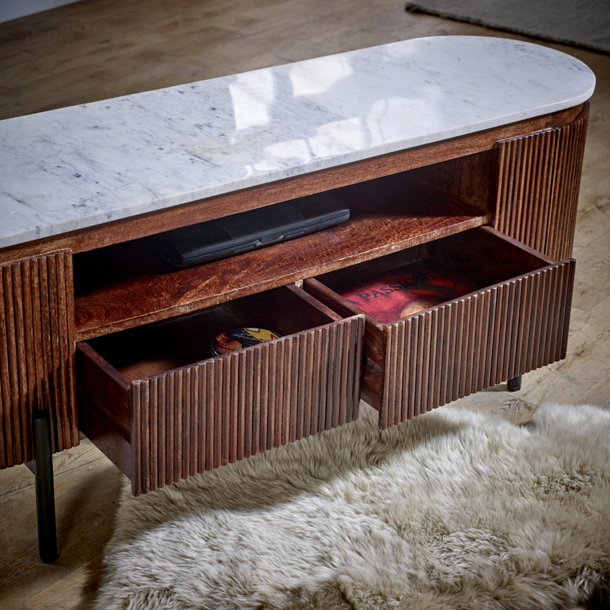 TV cabinet interior with open shelves and ribbed wood panels under a white marble top