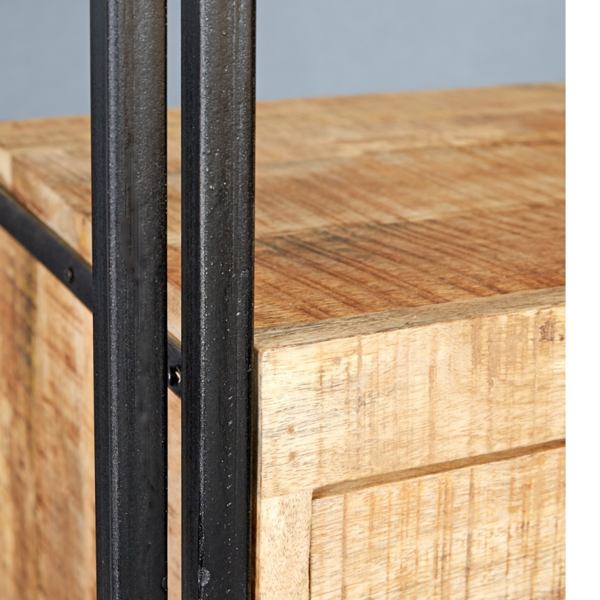 Close-up of industrial TV stand frame with black metal legs and light wood grain drawers