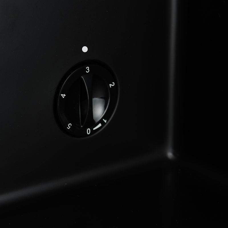 Temperature control dial on a black drinks fridge front panel