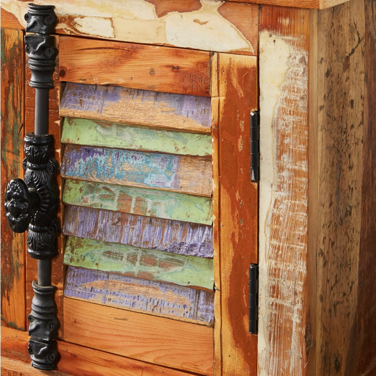 Reclaimed wood credenza close-up with layered multicolor paint and black metal hardware