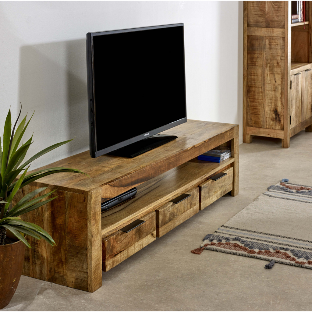 Corner view of rustic solid wood TV stand with open shelf and three drawer fronts.