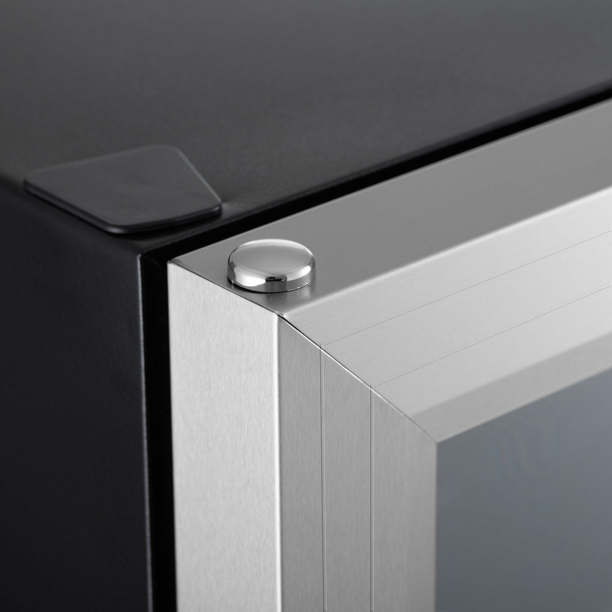 Silver metal side corner of a drinks fridge with black top trim