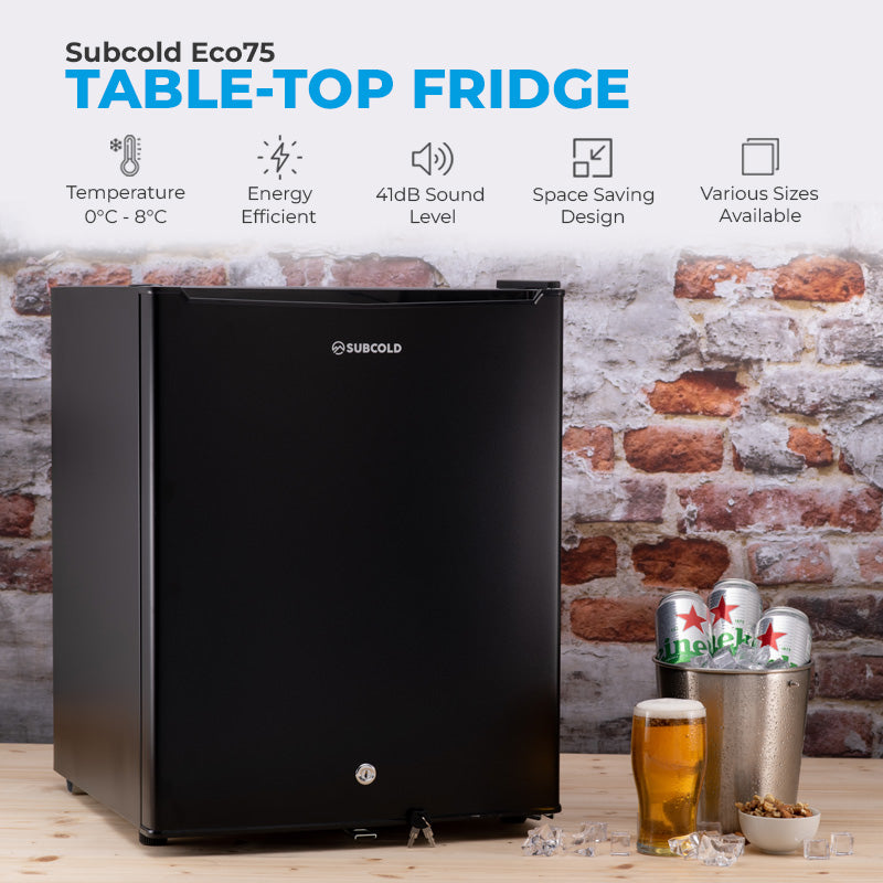 Black table-top fridge on floor with closed door