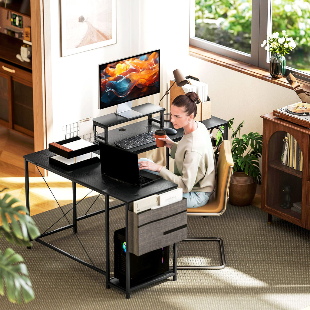 Black computer desk with monitor stand, cable space, and fabric storage drawer cabinet
