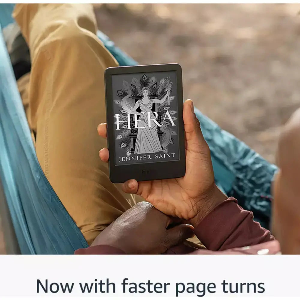 Black Kindle e-reader held outdoors, screen showing book cover title 'HERA'