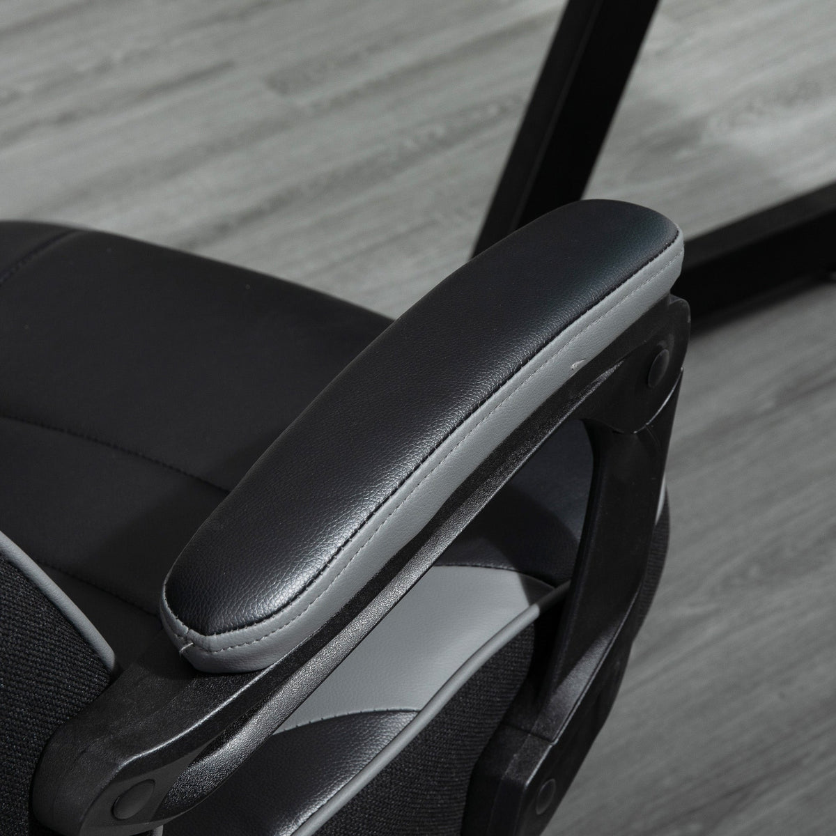 Gaming chair armrest with padded PU arm and side control detail; dark grey