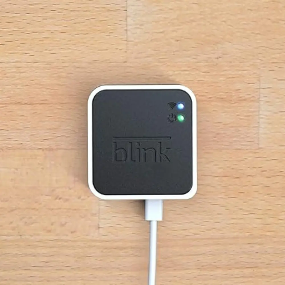 White Blink sync module with USB cable plugged in and green LED indicators.