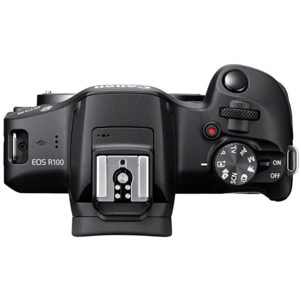 Black digital camera top view with mode dial, buttons, and hot shoe