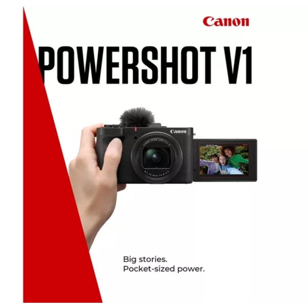 Canon PowerShot V1 compact camera held in hand, rear display screen visible