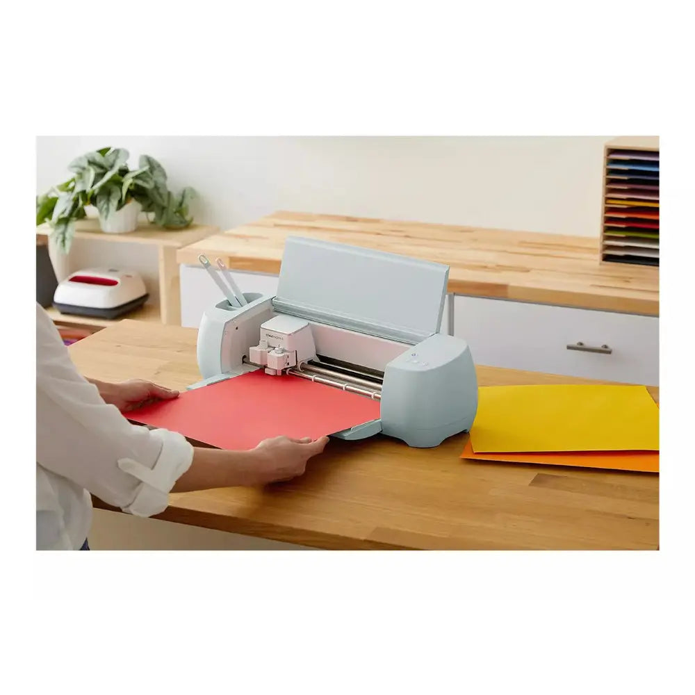 Cricut Hat Press with cap attachment pressing a shirt on a worktable