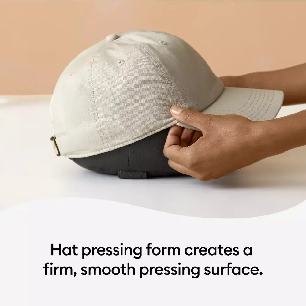 Hand placing a light gray cap on hat pressing base
