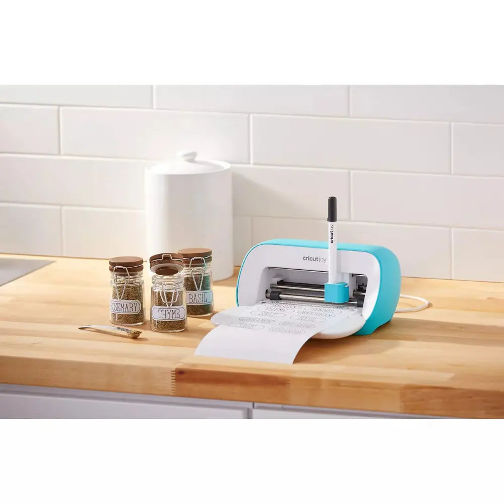Cricut Joy cutting machine on a work surface, turquoise frame and white base