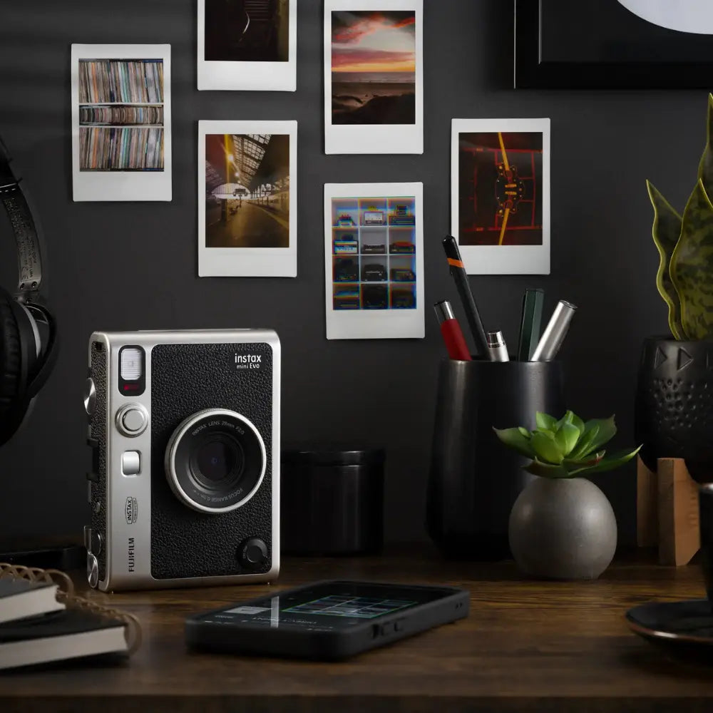 Hybrid instant camera with black textured body, lens, and printed photo