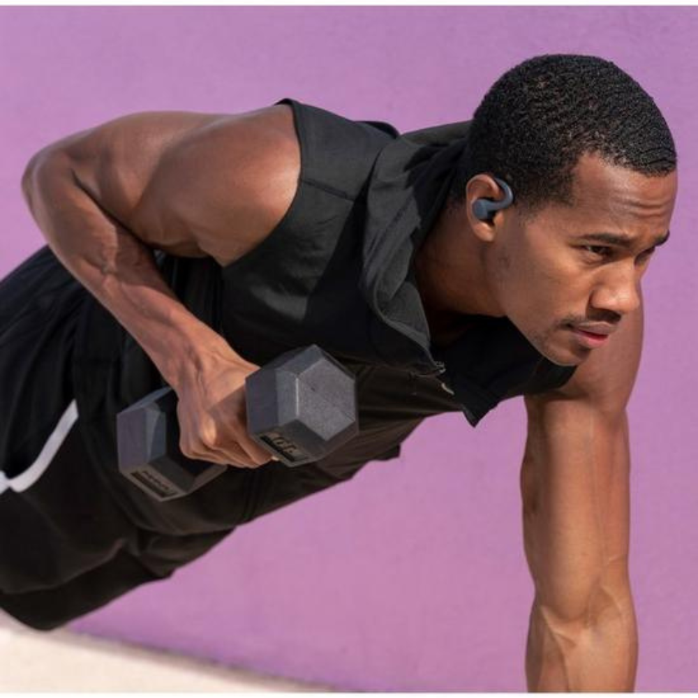 Black sport earbuds worn in-ear, showing secure ear hook and eartip