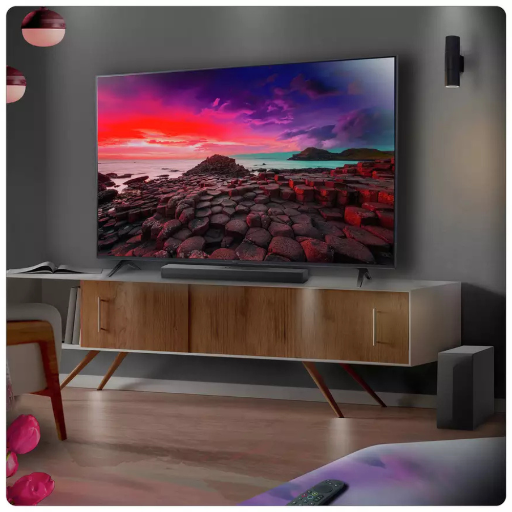 Sound bar under a TV with black wireless subwoofer speaker