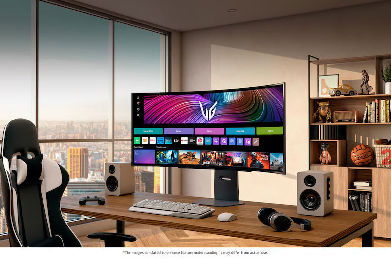 Curved OLED gaming monitor on desk in a home setup with keyboard and speakers.