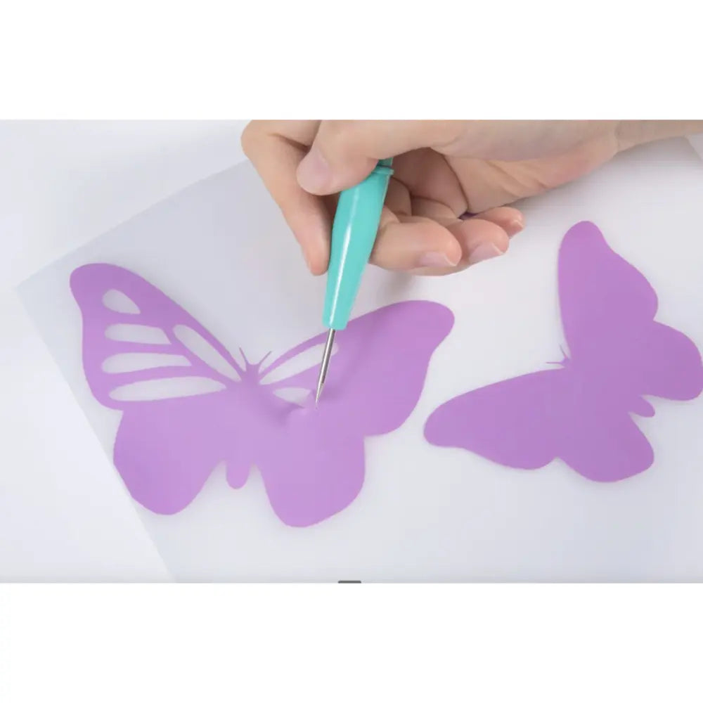 Craft starter pack: hand uses teal pen to outline purple butterfly shapes on paper