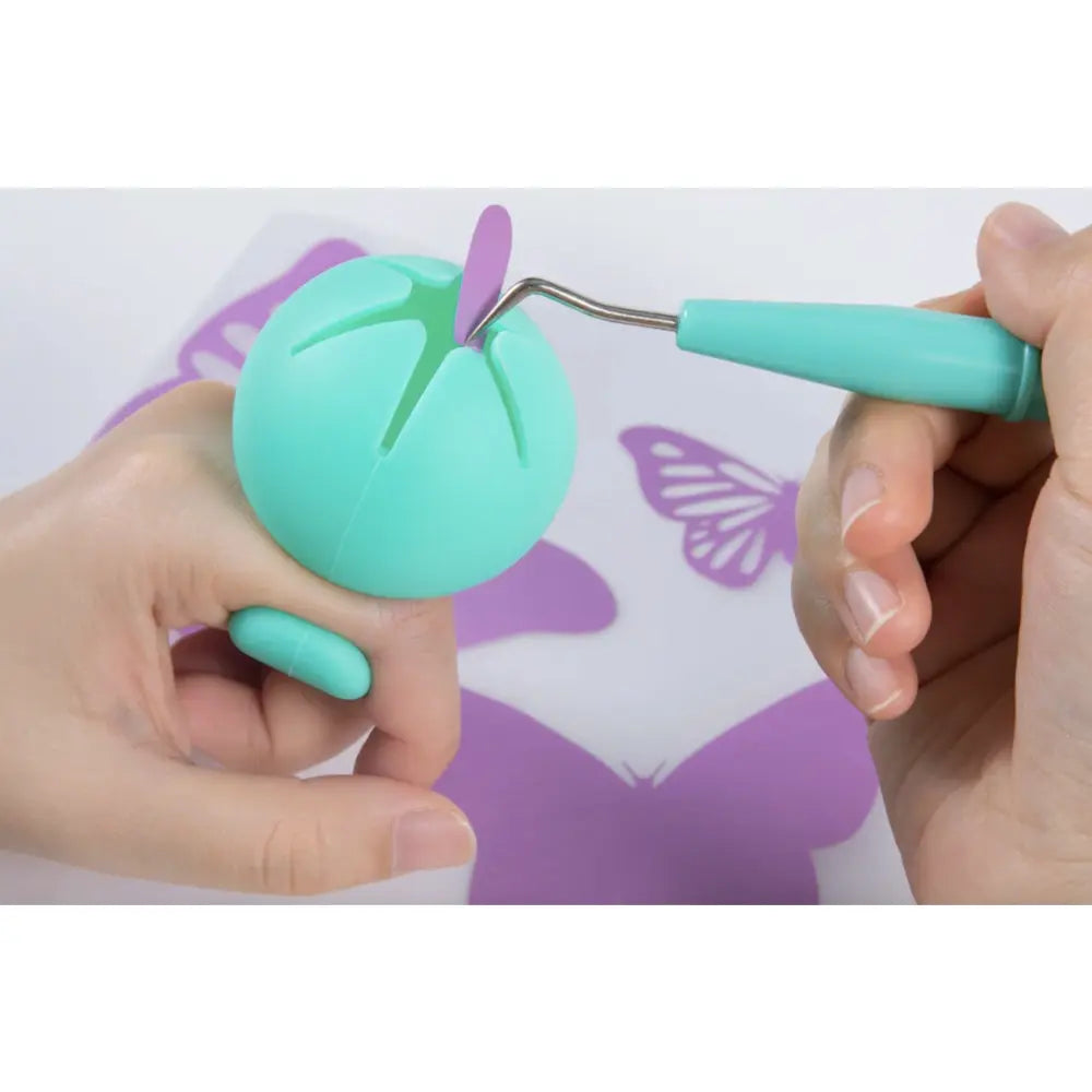 Craft starter pack: hands press teal tool into foam shape on purple butterfly stencil