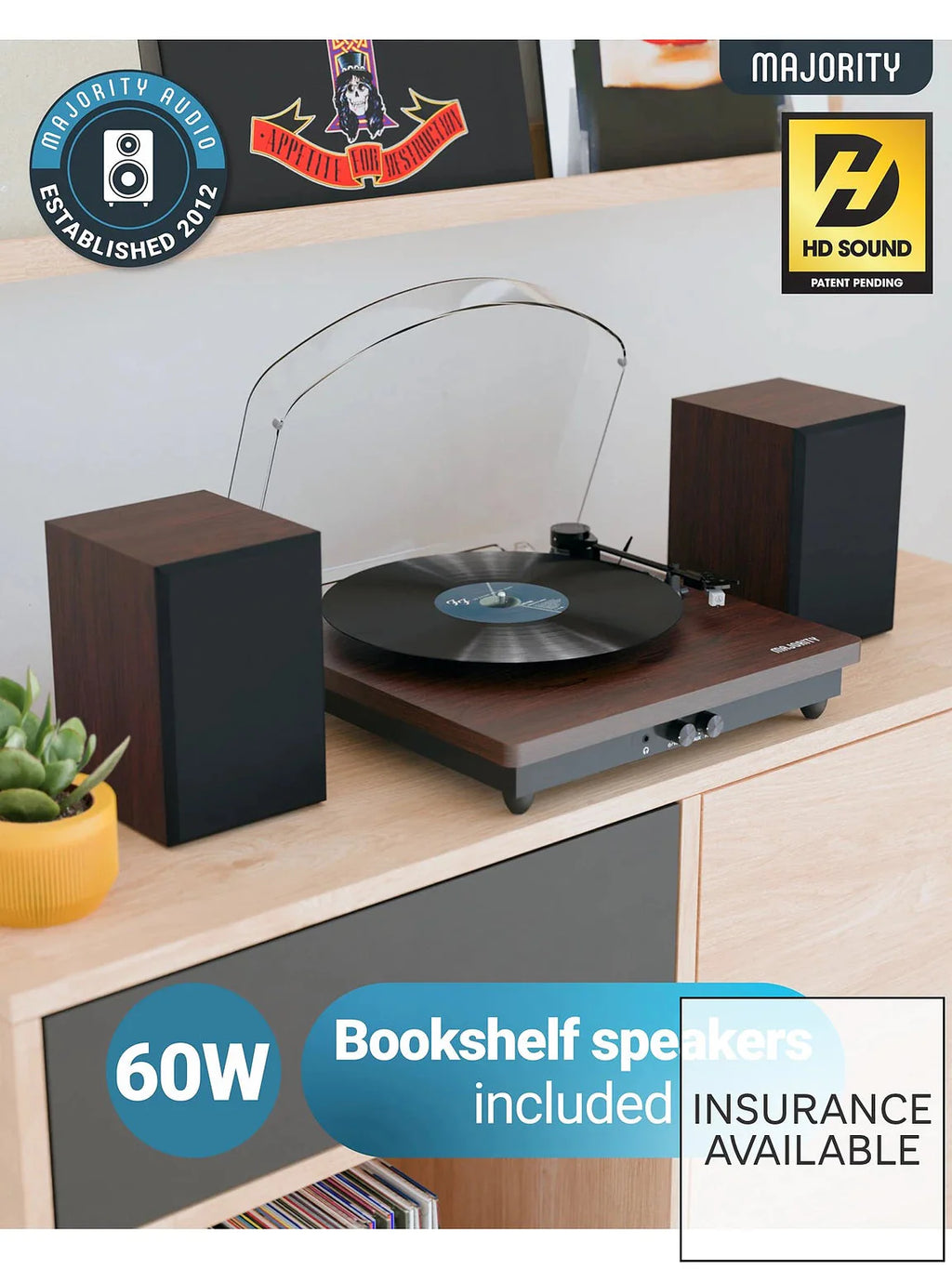 Wood turntable with vinyl platter and two black tower speakers on tabletop stand