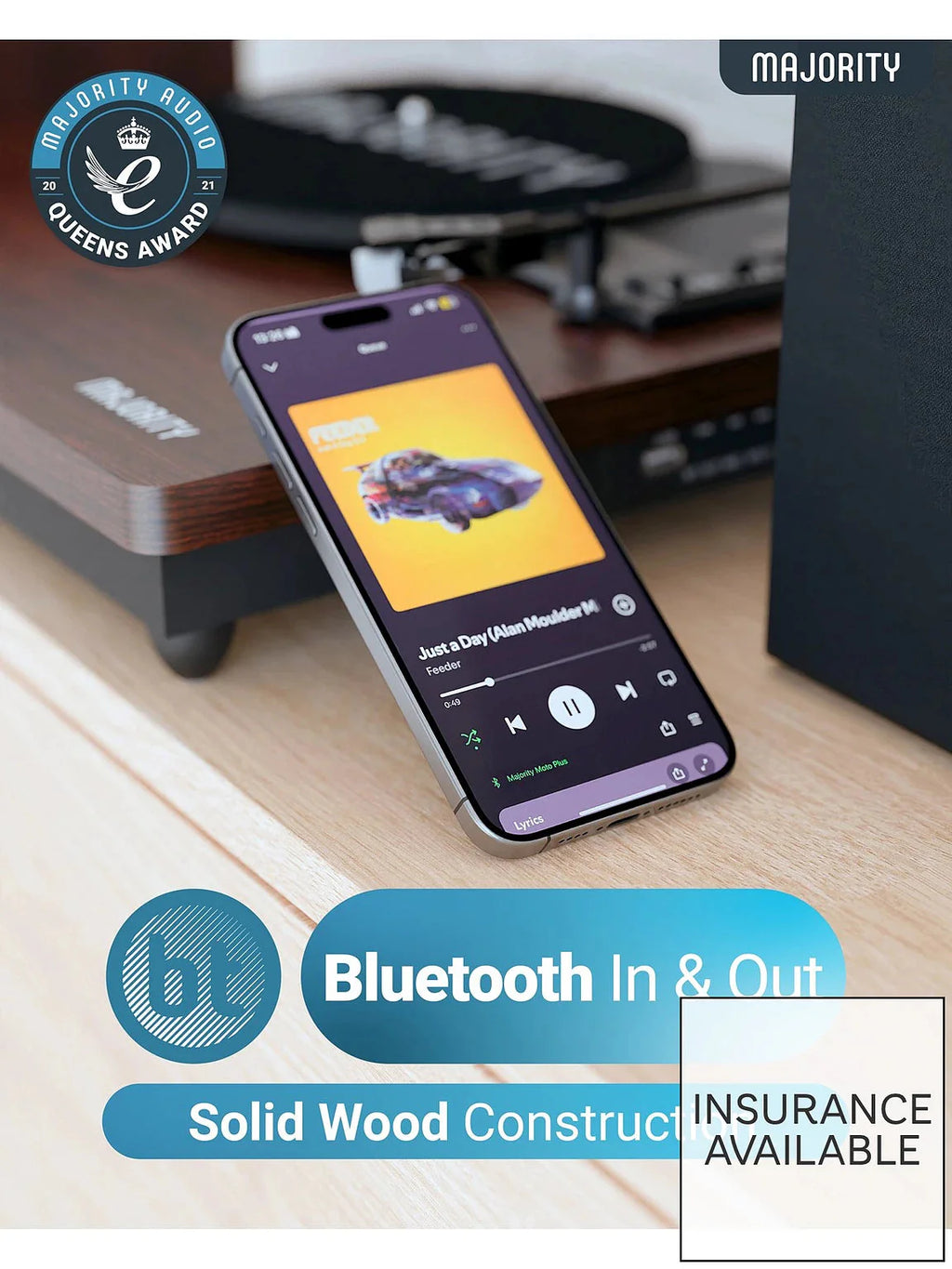 Turntable on desk with smartphone showing Bluetooth controls, dark wooden base