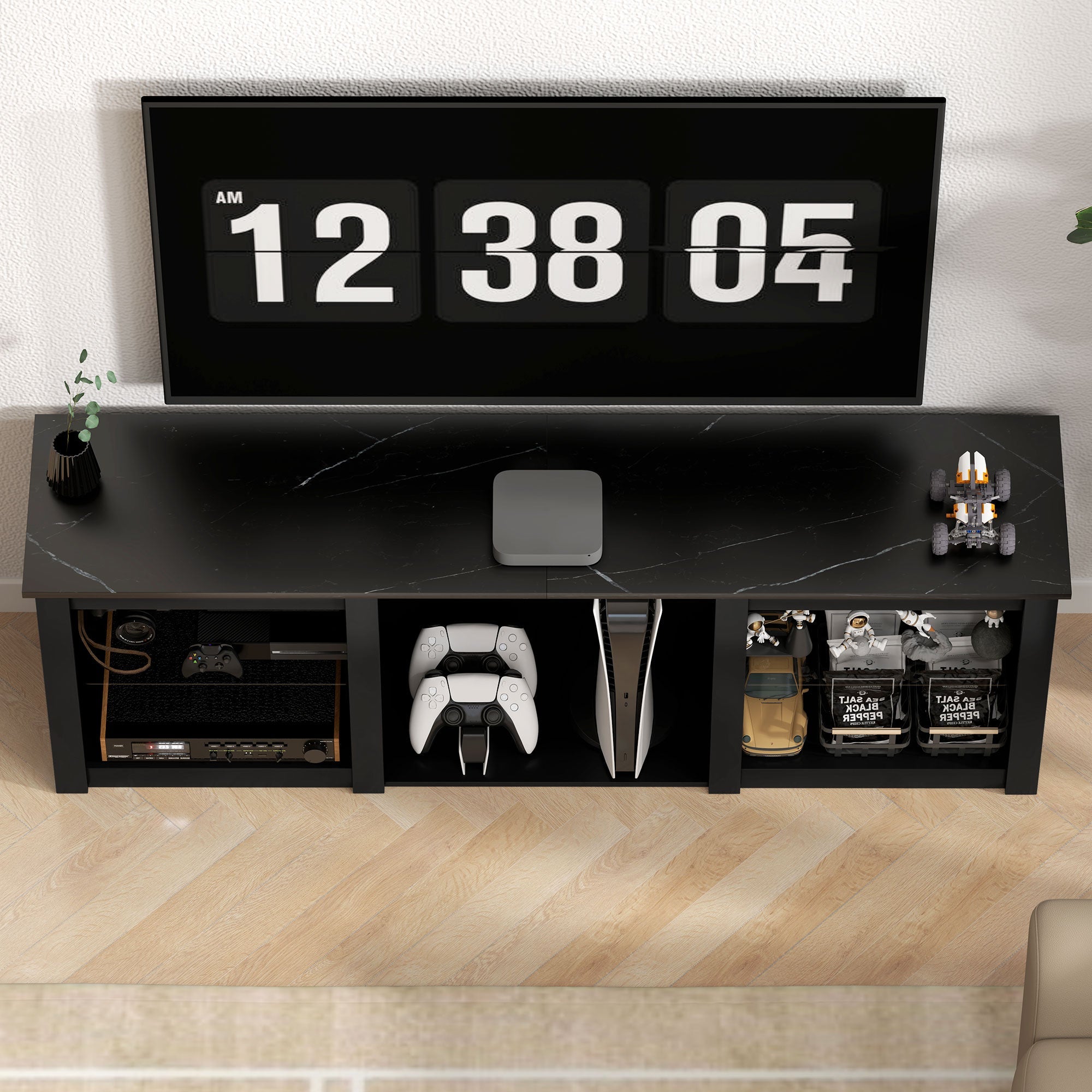 Black TV media cabinet with central console bay, open storage, and LED-style decor setup