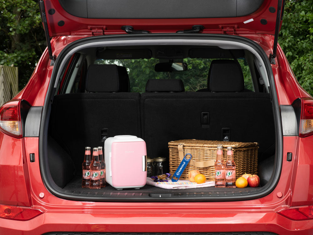 Pink mini fridge placed in car trunk with latch door open