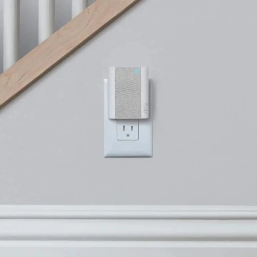Wall-mounted smart chime over a duplex outlet with gray textured face and blue light