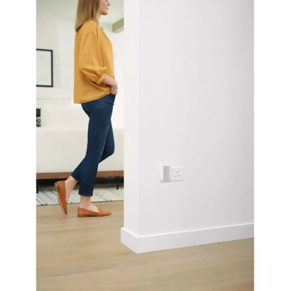 White wall corner with electrical outlet and mounted device not clearly visible