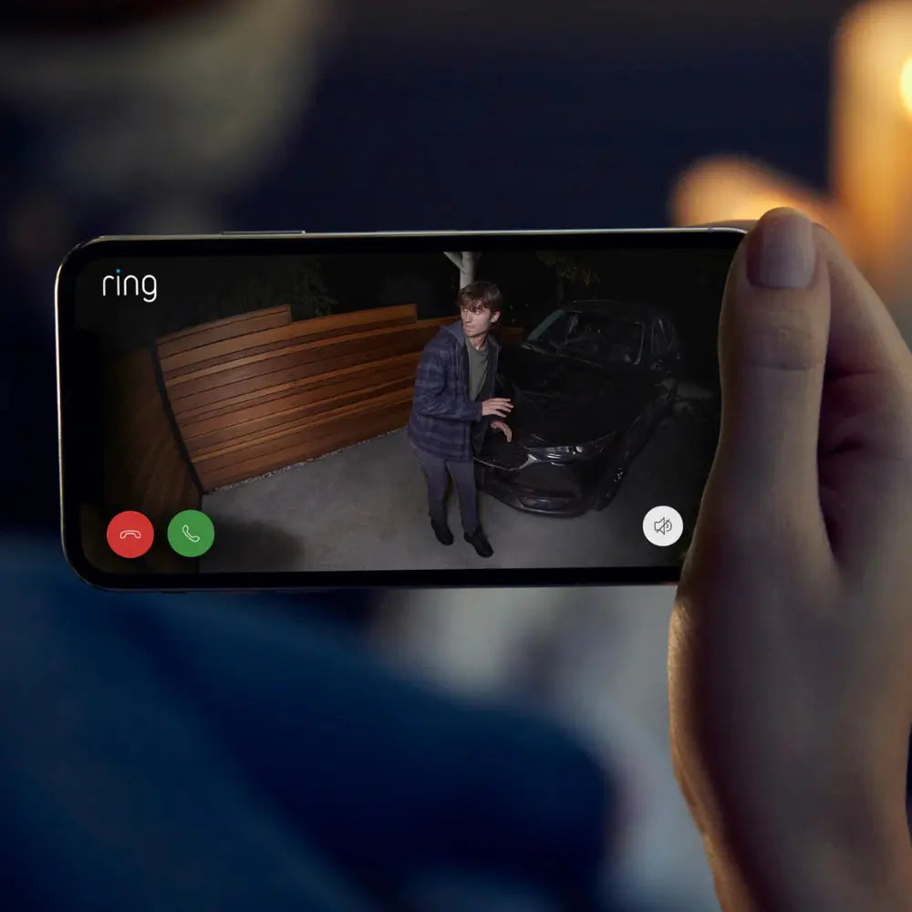 Ring Spotlight Cam Plus plug-in outdoor security camera with smartphone showing live video