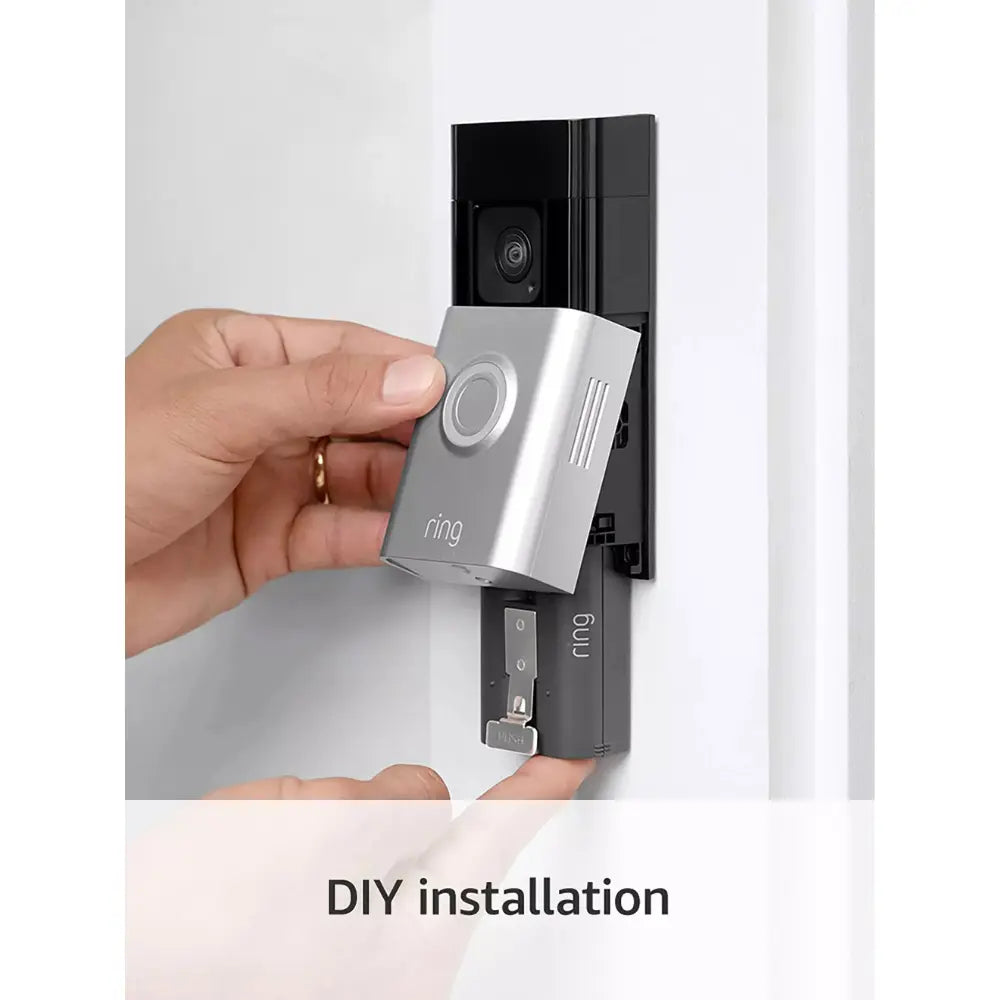 Silver battery video doorbell camera being installed by hand on door frame