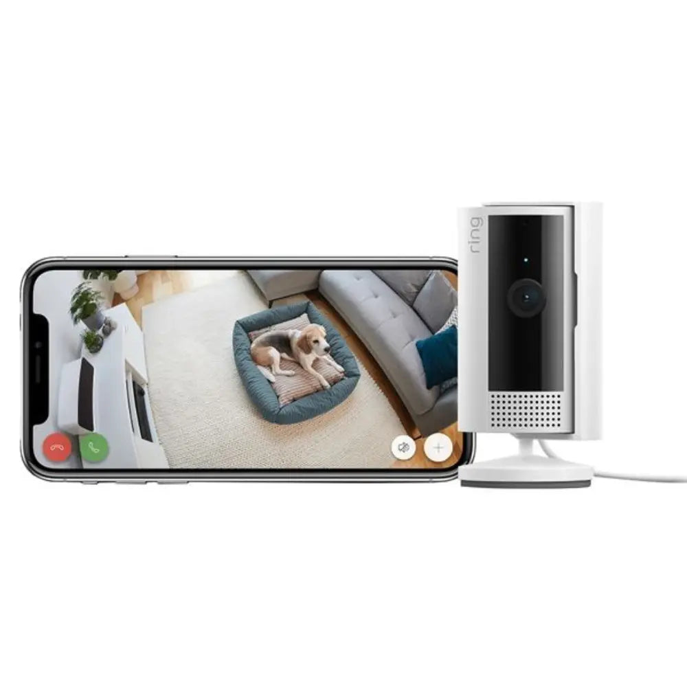 White indoor security camera beside phone showing live view