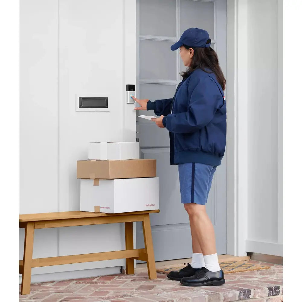Video doorbell at a front door with a delivery person standing at the entry