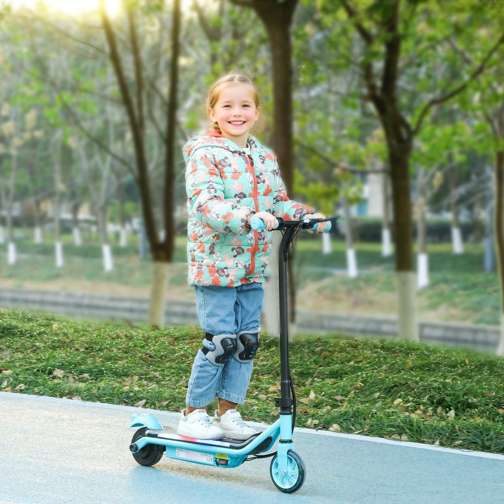 Child standing on a light blue kids electric scooter with glowing front wheel