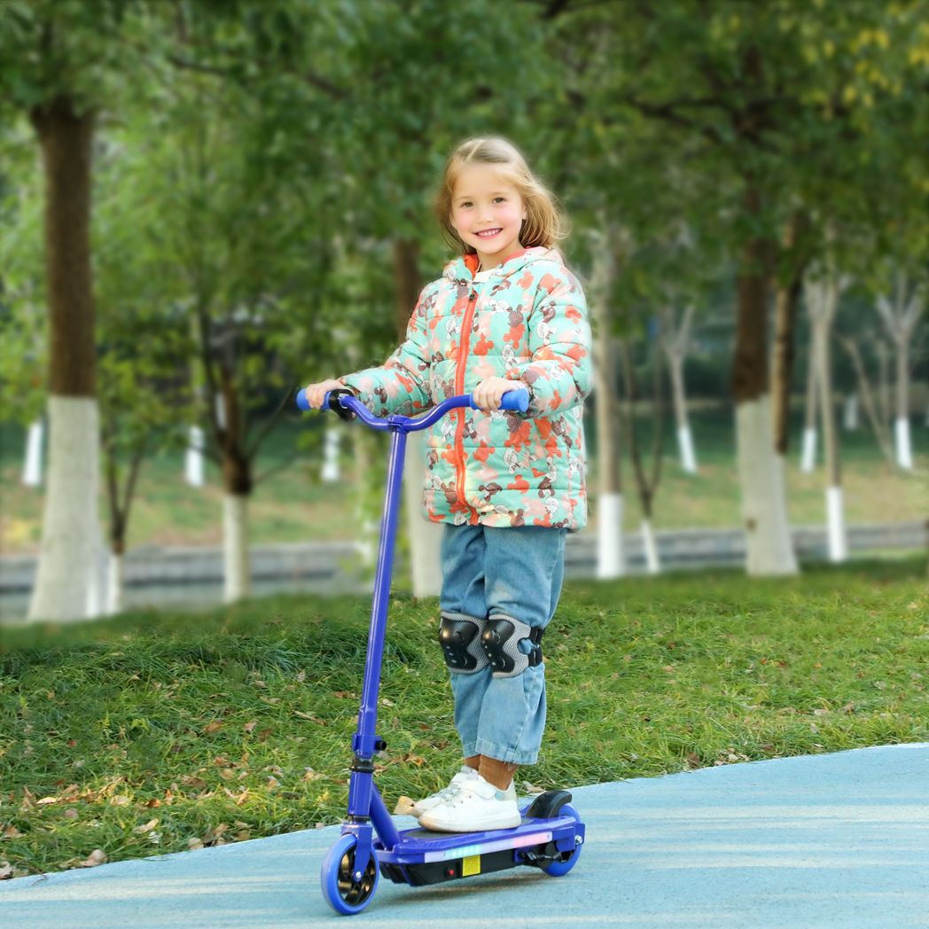 Child standing on a blue electric scooter with lit deck lights outdoors