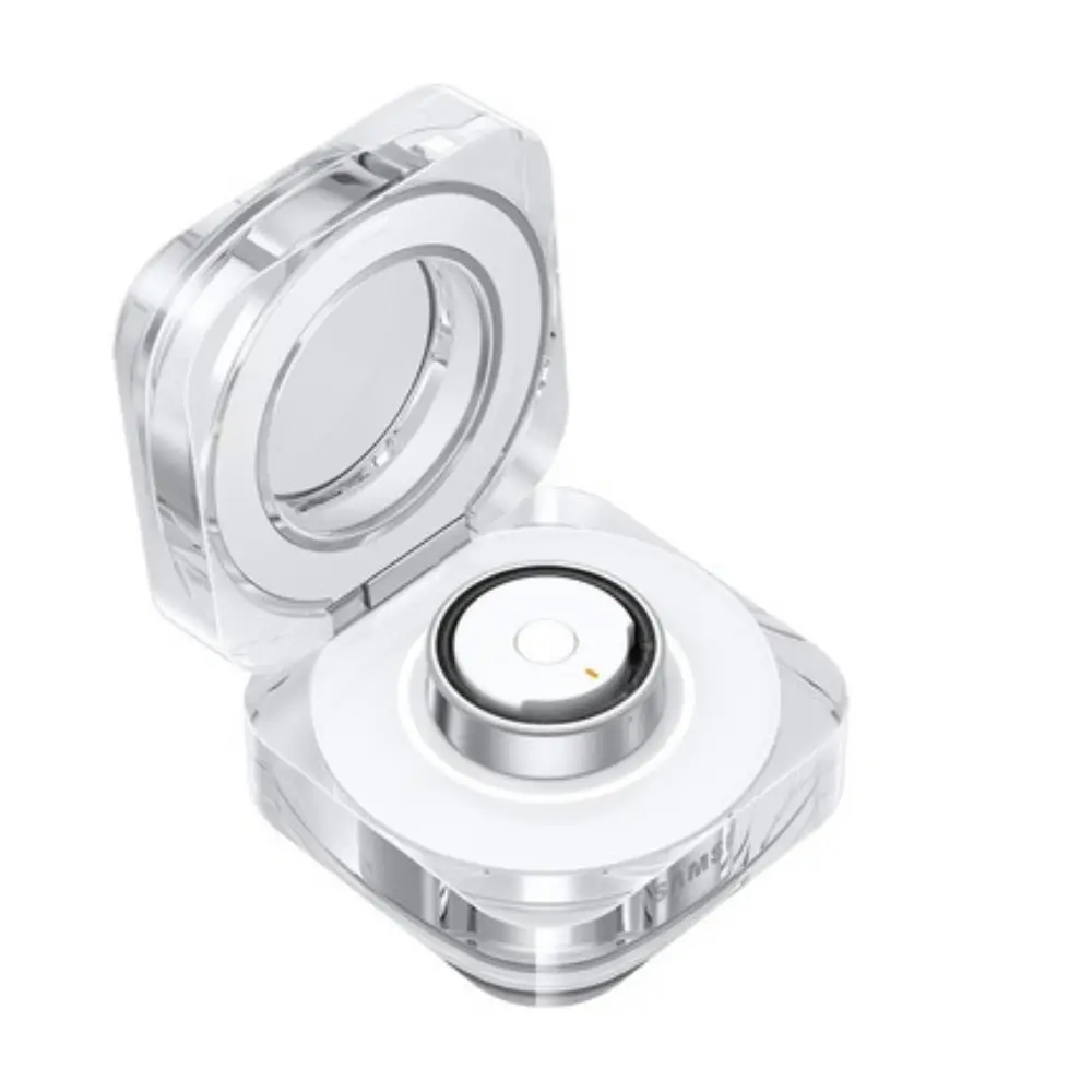 Titanium silver smart ring in open clear case with black sensor top on white module