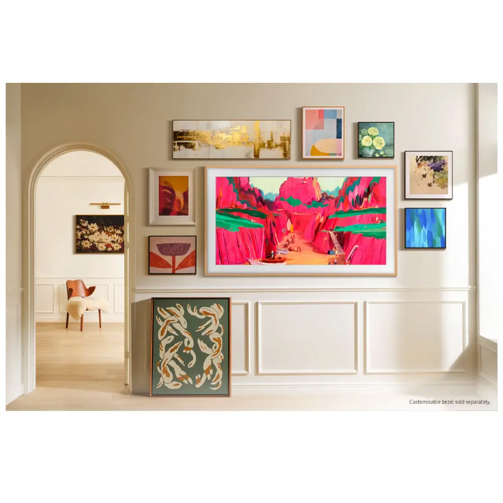 Wall-mounted slim-frame art TV displaying colorful landscape artwork in a living room.