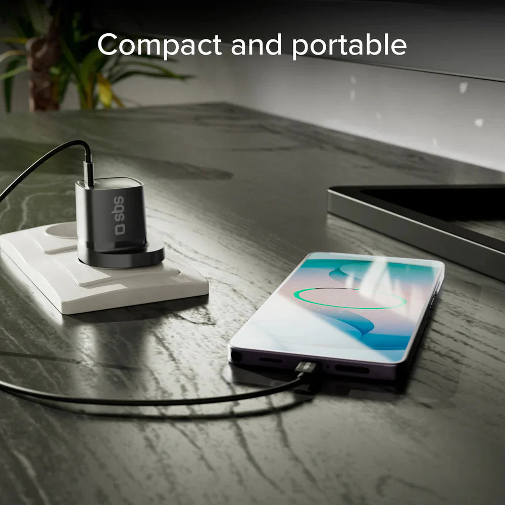 Black compact USB-C wall charger with connected cable on countertop