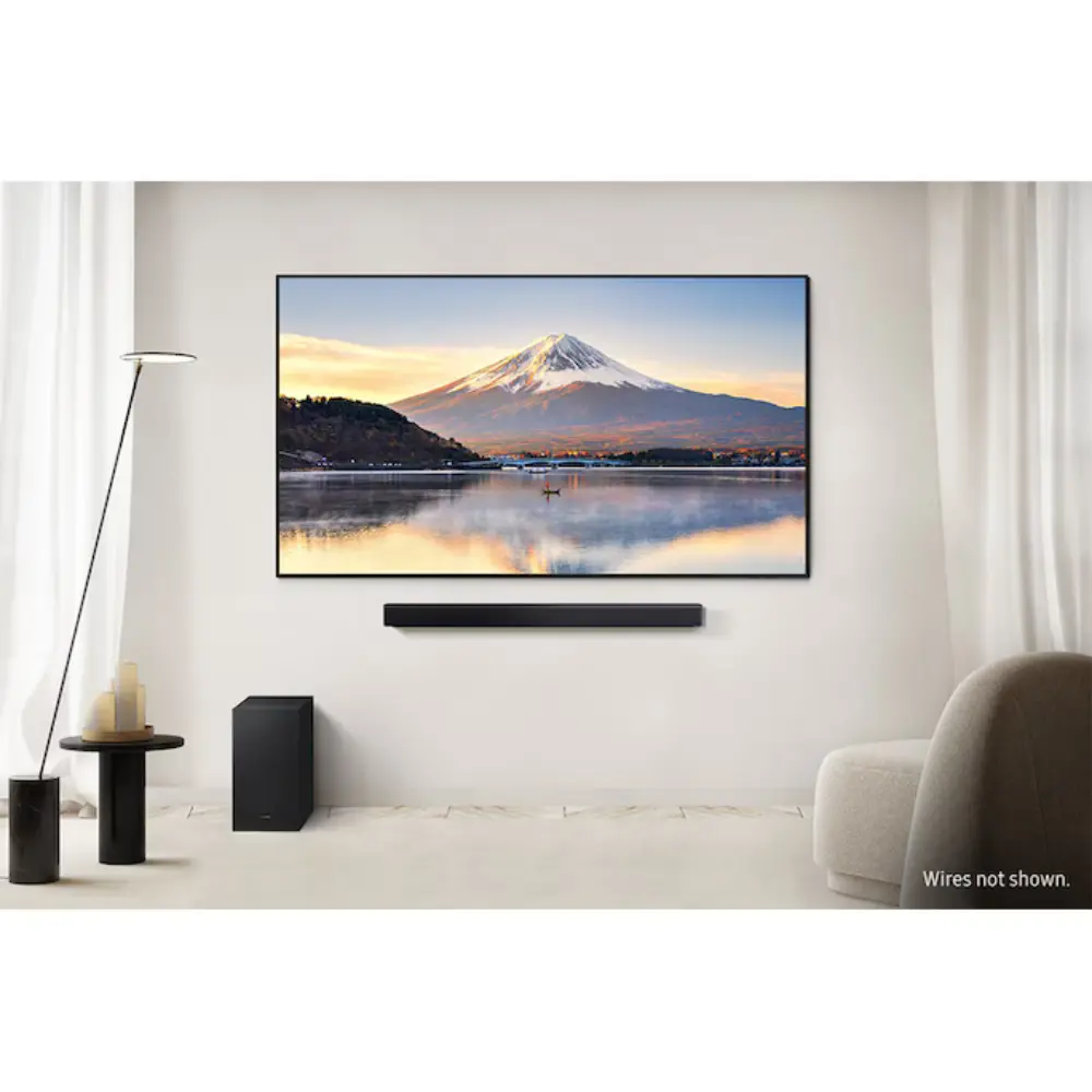 Soundbar and subwoofer setup under a wall-mounted TV in a bright living room
