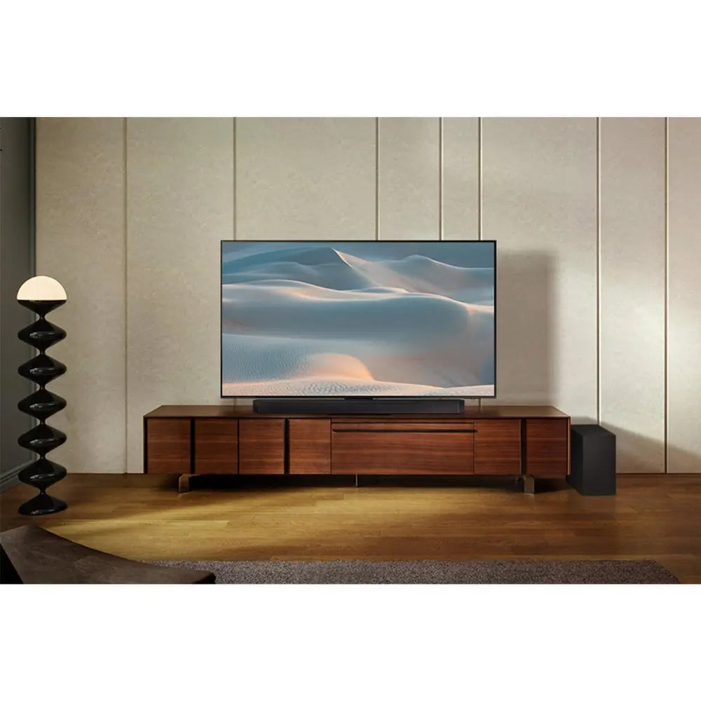 Soundbar on media console beneath TV screen, sleek low-profile bar