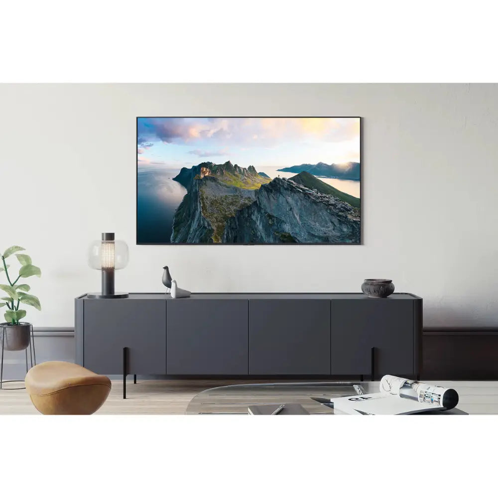 Samsung TV on media console showing mountain landscape scene