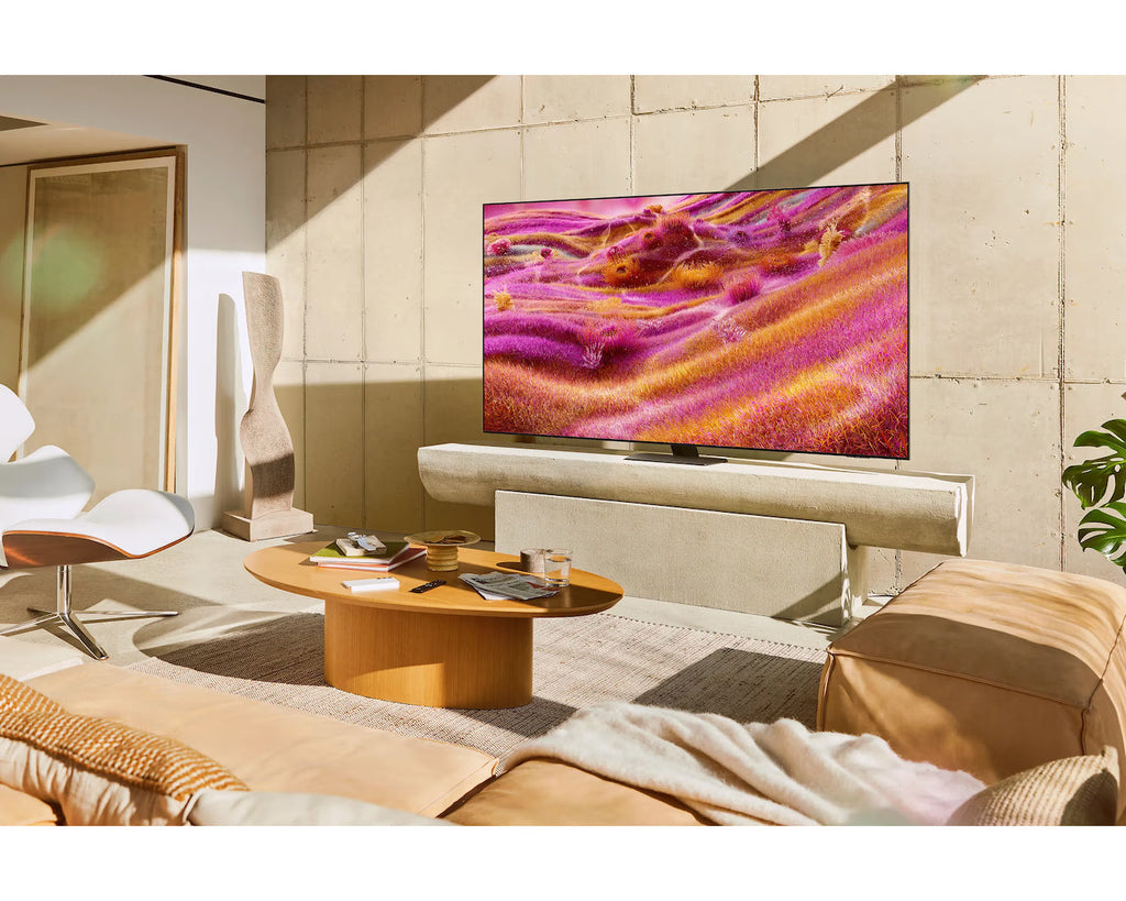 Samsung Neo QLED 4K TV on wall above console, colorful beach display