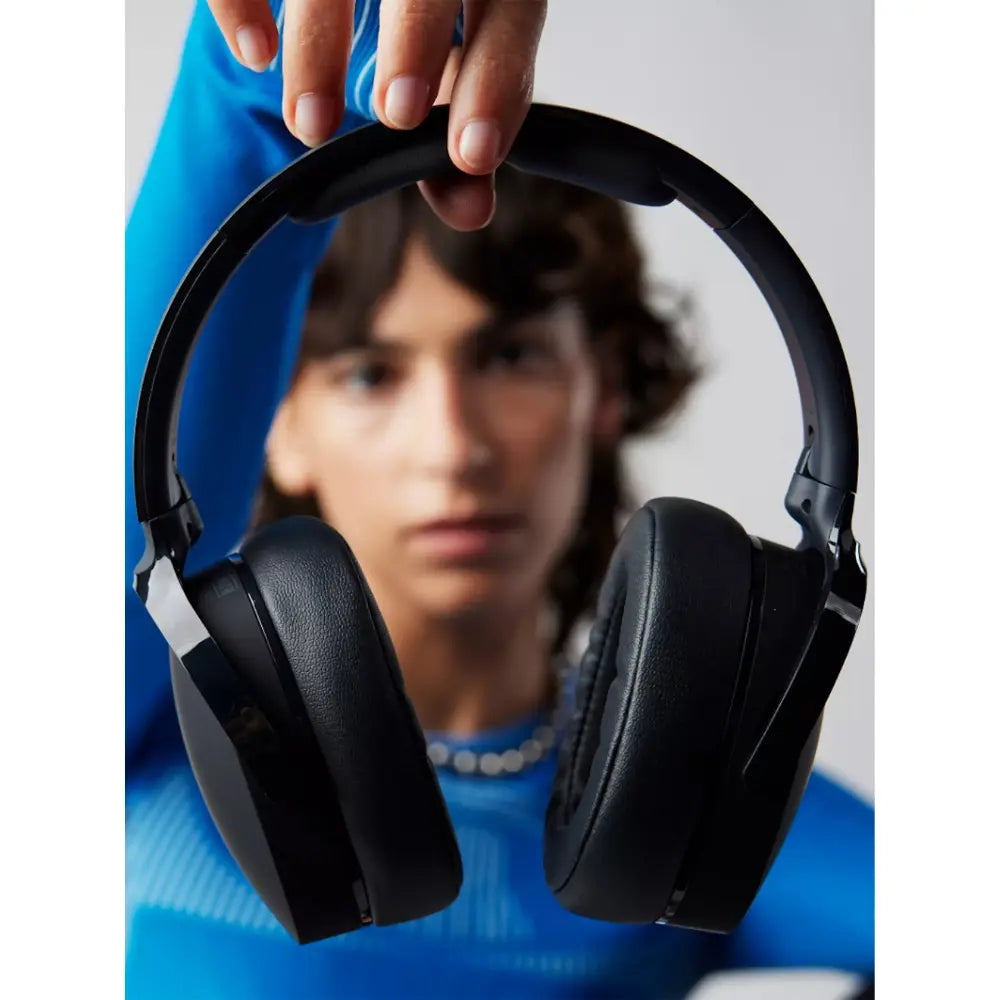 Black over-ear headphones with hand adjusting the headband
