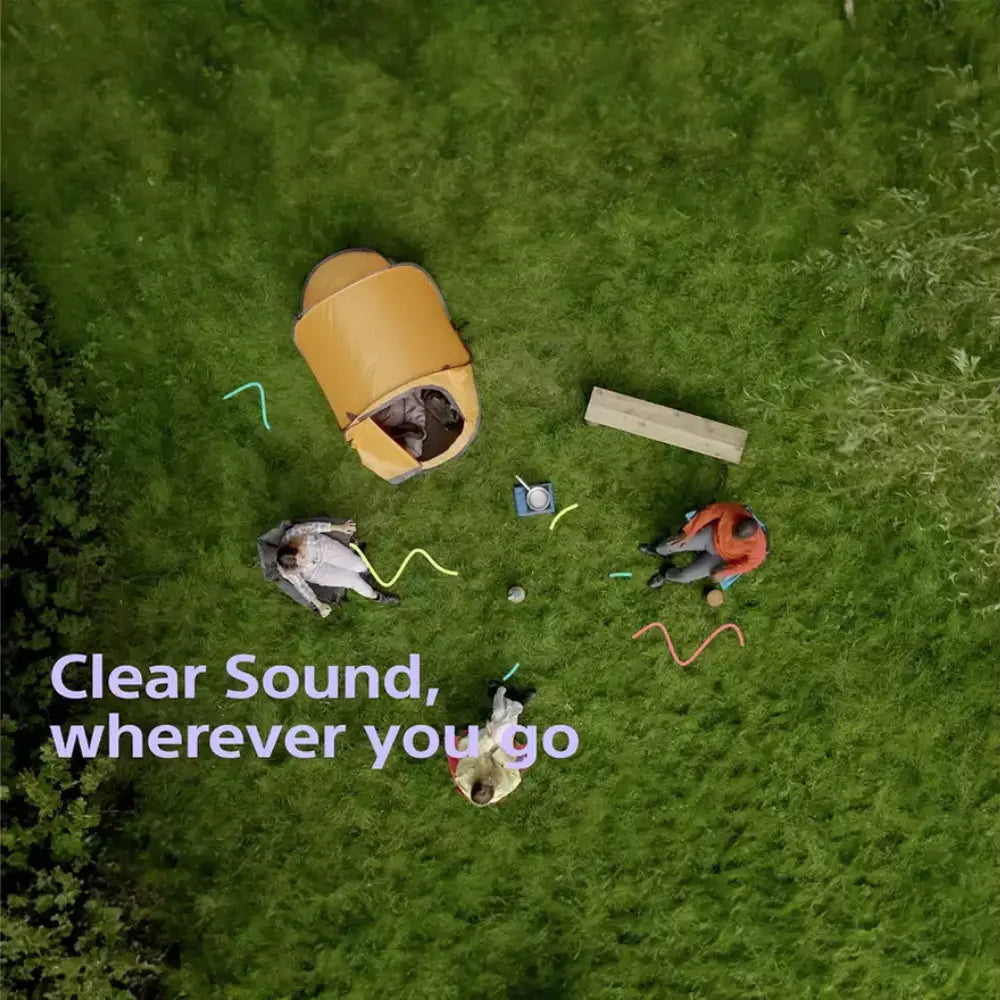 Sony SRS-XB100 portable Bluetooth speaker, blue cylinder on green grass